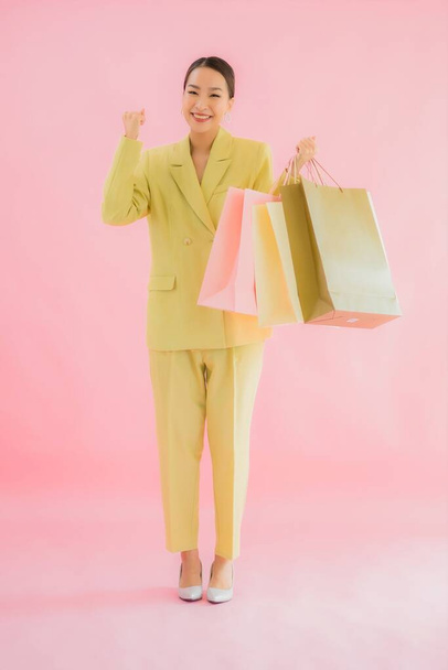 Portrait beautiful young asian business woman with shopping bag on color isolated background - Foto, afbeelding