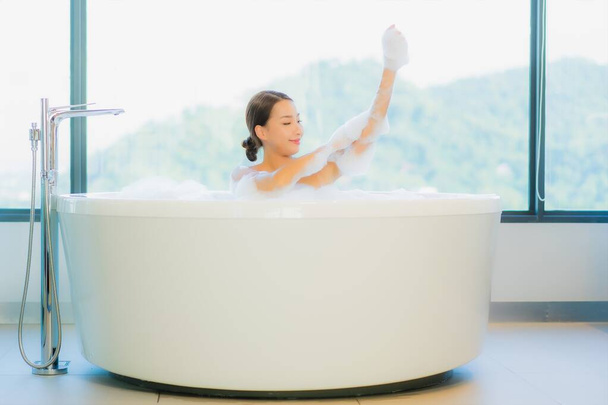 Muotokuva kaunis nuori aasialainen nainen rentoutua vapaa nauttia kylpyammeessa kylpyhuoneessa ja wc sisustus - Valokuva, kuva