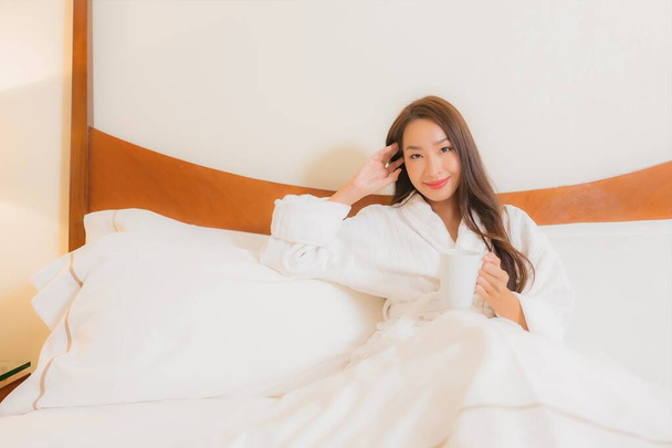 Portret piękna młoda azjatycka kobieta uśmiech relaks na łóżku we wnętrzu sypialni - Zdjęcie, obraz