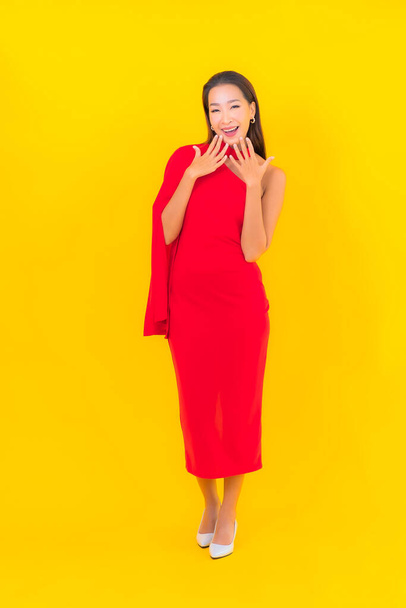 Portrait beautiful young asian woman smile with action on yellow isolated background - Φωτογραφία, εικόνα