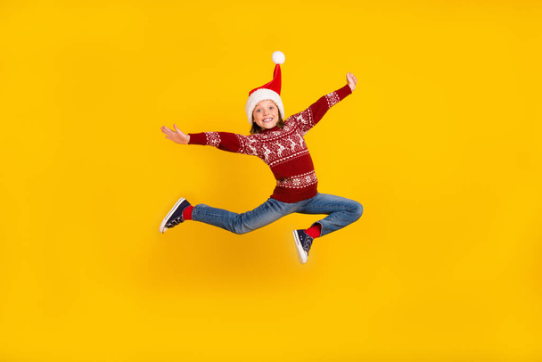 Full body photo of cheerful little happy girl jump up christmas sale isolated on yellow color background - Fotografie, Obrázek