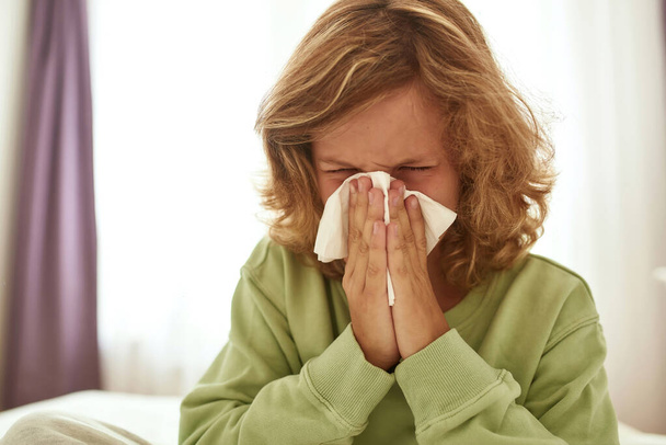Sick teenage boy blow nose have cold - Photo, image