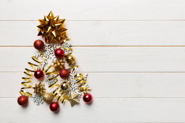 Árbol de Navidad hecho de decoración de bolas de colores sobre fondo de color, vista desde arriba. Concepto mínimo de Año Nuevo con espacio de copia. - Foto, imagen
