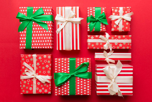 Wiele pudełek na prezenty świąteczne w kolorowym papierze urządzone na stole, widok z góry zbliżenie. Wiele prezentów noworocznych. - Zdjęcie, obraz