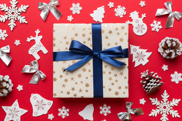 Рождественская композиция Подарочная коробка с новогодними украшениями на цветном фоне. Рождество, зима, новый год. Плоская кладка, вид сверху, копировальное пространство. - Фото, изображение