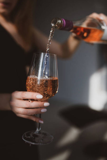 Uma mulher derramando vinho em um copo - Foto, Imagem