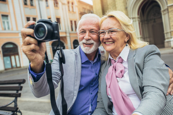  Couple sénior découvrant une nouvelle ville en prenant des photos sur caméra rétro - Photo, image