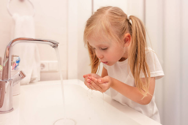 Küçük kız sabahları dişlerini yıkıyor. Parlak banyo. Diş temizliği - Fotoğraf, Görsel