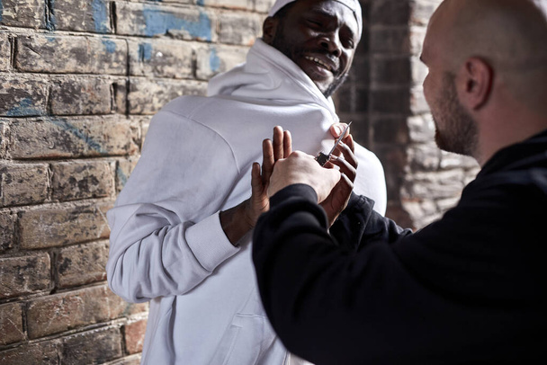 Street theif commits robbery attack on african man, at day time. crime concept - 写真・画像