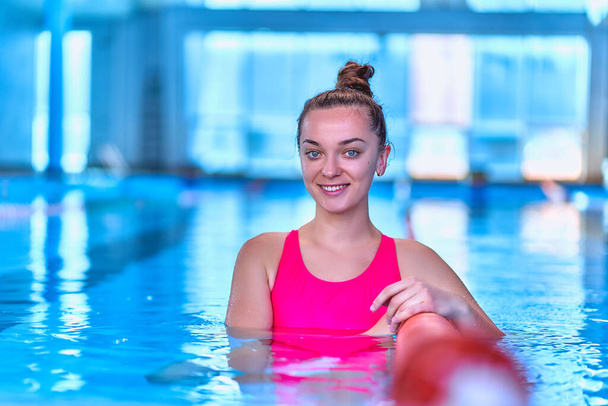 Portrait of young happy cute swimmer woman in swimsuit during relaxing in swimming sports pool in leisure centre, healthy lifestyle         - Foto, Bild
