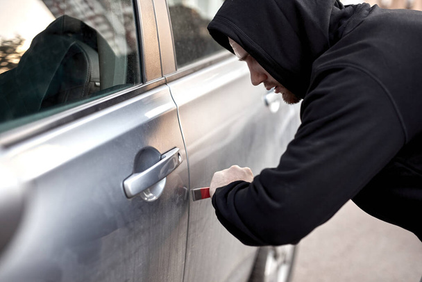 Car thief steal car breaking door criminal job burglar Hijacks Auto thief in black wear - Foto, immagini