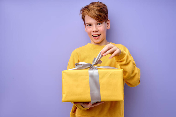 Surprised emotional curious adorable little boy unpacking present gift box - Foto, Imagem