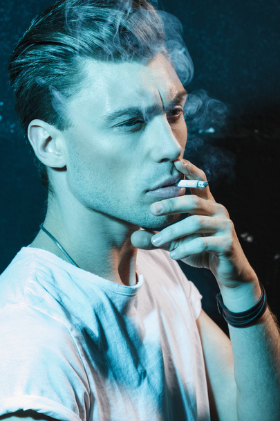 Handsome young man smoking cigarette - Photo, Image