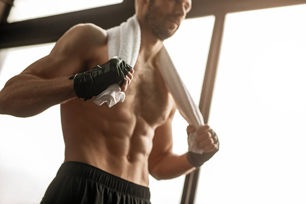 Sweaty male athlete with bandages on arm - Zdjęcie, obraz