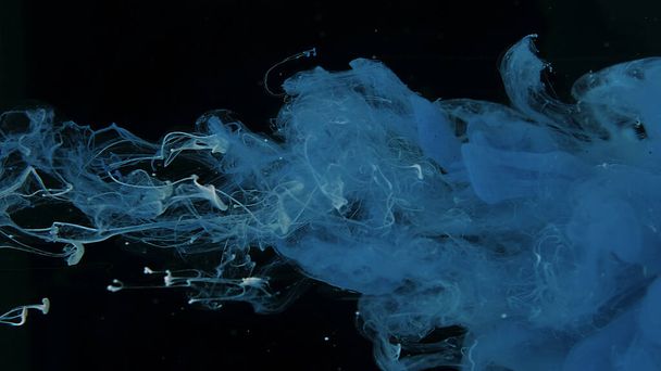 Beautiful wallpaper for your desktop. Blue cloud of ink on a black background. Drops of blue ink in water. Blue and white watercolor paints in water on a black background. Awesome abstract background. - Φωτογραφία, εικόνα
