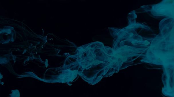 Creative hyptonic background. Blue-green cloud of ink on a black background. Beautiful abstract background. Blue-green watercolor paints in water on a black background. Chic wallpaper for your desktop. - Φωτογραφία, εικόνα