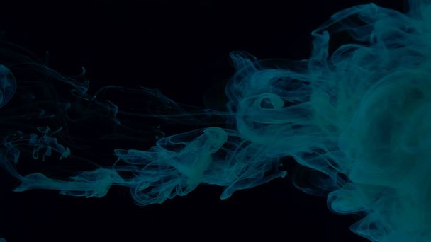 Blue-green cloud of ink on a black background. Beautiful abstract background. Blue-green watercolor paints in water on a black background. Chic wallpaper for your desktop. Creative hyptonic background. - Fotoğraf, Görsel