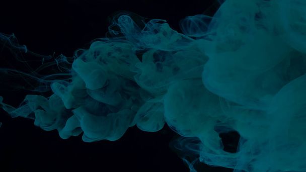 Blue-green watercolor paints in water on a black background. Chic wallpaper for your desktop. Creative hyptonic background. Blue-green cloud of ink on a black background. Beautiful abstract background. - Foto, Bild