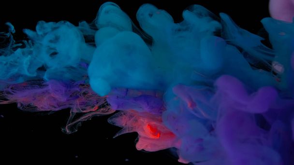 Drops of blue, purple and pink ink in water. Blue, purple and scarlet watercolor paints in water on a black background. Awesome abstract background. Beautiful wallpaper for your desktop. Colored cloud of ink on a black background. - Foto, Imagen