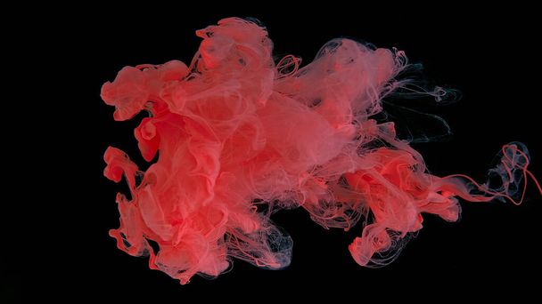 Drops of pink ink in water. Pink watercolor paints in water on a black background. Awesome abstract background. Beautiful wallpaper for your desktop. Pink cloud of ink on a black background. - Foto, Imagem