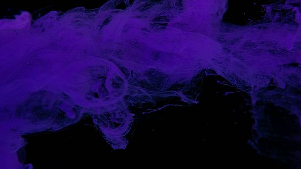 Violet cloud of ink on a black background. Drops of purple ink in water. Purple watercolor paints in water on a black background. Awesome abstract background. Beautiful wallpaper for your desktop. - Photo, Image