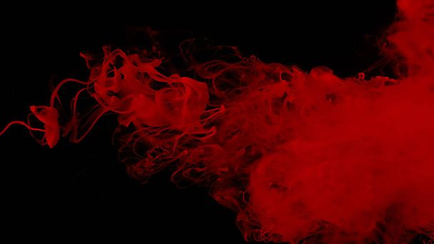 Drops of red ink in water. Cosmic star background. Red watercolor paints in water on a black background. Beautiful wallpaper for your desktop. Red cloud of ink. Awesome abstract background. - Foto, imagen