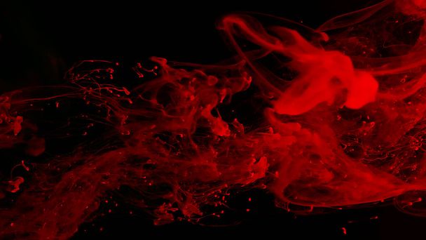 Drops of red ink in water. Cosmic star background. Red watercolor paints in water on a black background. Beautiful wallpaper for your desktop. Red cloud of ink. Awesome abstract background. - Фото, изображение