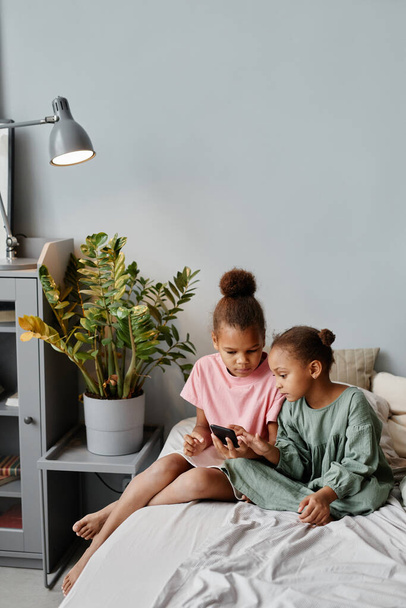 Dos chicas afroamericanas usando Smartphone en casa - Foto, Imagen