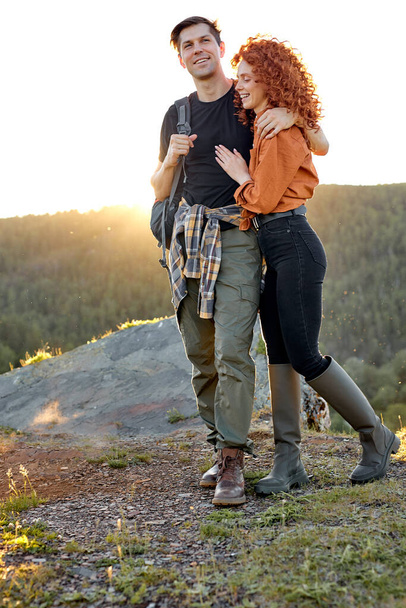 Attractive male and female on the head of mountains in nature, travelling together - 写真・画像