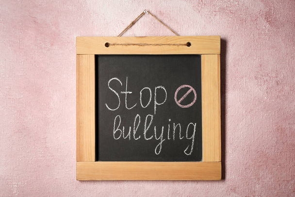 Blackboard with phrase Stop Bullying and prohibition sign on pink wall - Фото, зображення