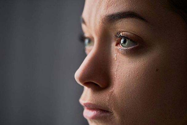 Mujer triste llorando desesperada con lágrimas en los ojos durante los problemas, dificultades para la vida, pérdida y problemas emocionales - Foto, imagen