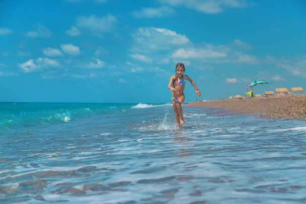 El niño corre a lo largo de la playa del mar. Enfoque selectivo. Niño., - Foto, imagen