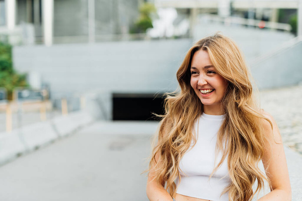 Retrato jovem caucasiano longo loira cabelo ao ar livre sorrindo saudável e feliz - Foto, Imagem