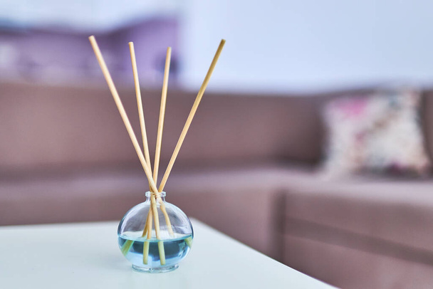 Aroma sticks and essential oil bottle in home interior  - Photo, image