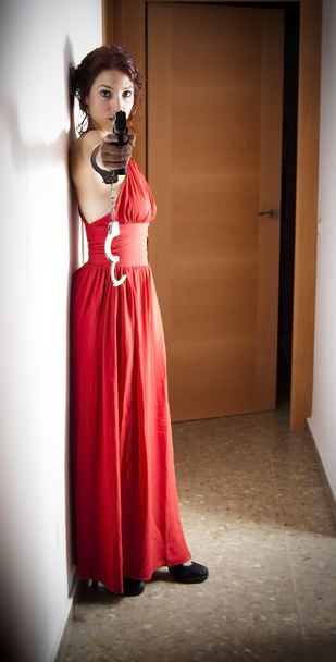 kırmızı bir elbise ve silah ile güzel bir kadın - Fotoğraf, Görsel