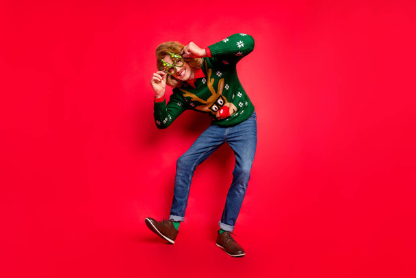 Plná délka tělo velikost pohled na atraktivní veselý chlap tanec s zábavou blázinec izolované přes jasně červené barvy pozadí - Fotografie, Obrázek