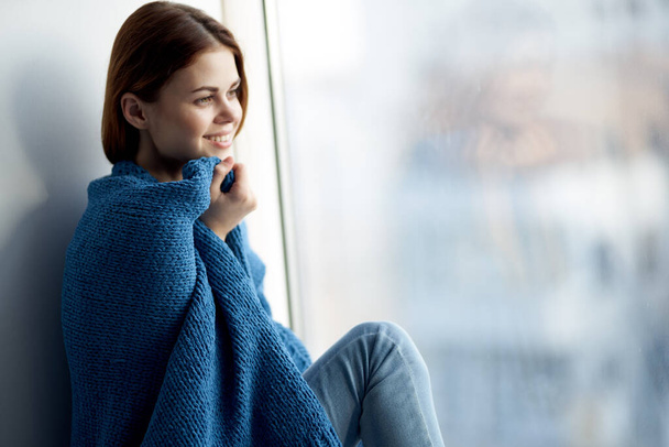 kaunis nainen istuu ikkunalaudalla sininen ruudullinen - Valokuva, kuva