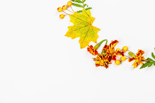 Autumn frame composition, isolated on a white background. A wreath from decorative fall leaves, berries, and marigold flowers - Photo, Image