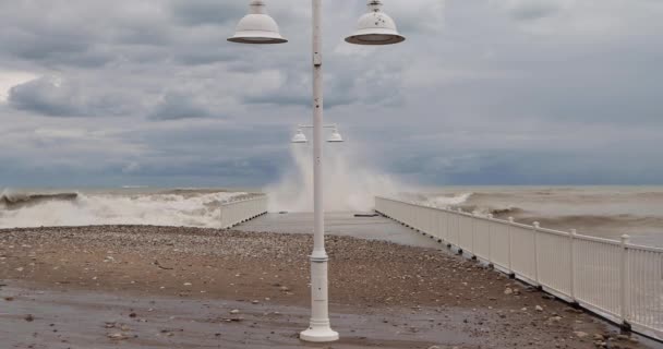 Хвилі розбиваються об пірс біля пляжу Гленко поблизу Чикаго на вітряний день уздовж озера Мічиган.. - Кадри, відео