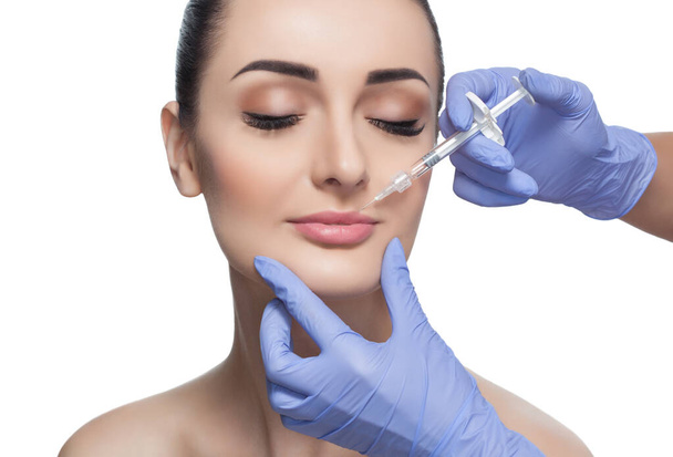 O médico cosmetologist faz Lip procedimento de aumento de uma mulher bonita em um salão de beleza. Cosmetology cuidados com a pele. - Foto, Imagem
