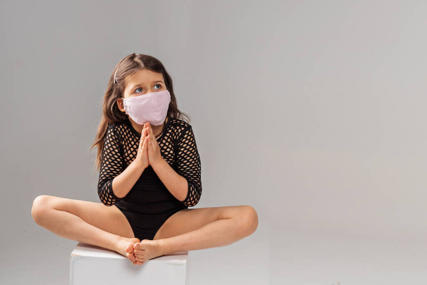 Junge Mädchen tragen Masken, um Krankheiten vorzubeugen, Kaukasierin betet für Genesung - Foto, Bild