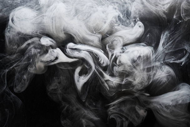 Abstract dark paint in water background. White smoke cloud motion on black, acrylic ink swirl splashes - 写真・画像