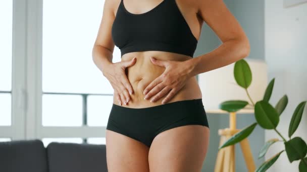 Donna che comprime la pelle dello stomaco e dei fianchi controllando la cellulite e il grasso sottocutaneo in eccesso - Filmati, video