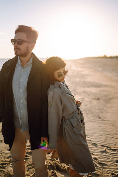 Fashion couple enjoying each other on beach during autumn sunny day. Travel, weekend, relax .and lifestyle concept.  - Foto, Imagem