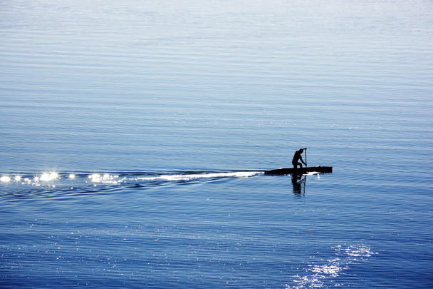 Один человек с каноэ на озере
 - Фото, изображение