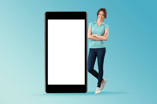 Mobile offer. Happy lady leaning on the huge cellphone with empty screen, - Zdjęcie, obraz