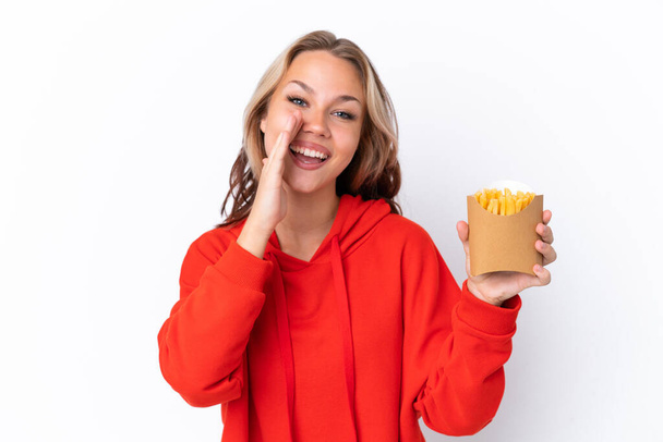 Fiatal orosz lány kezében sült chipek elszigetelt fehér háttér kiabál száj széles nyitott - Fotó, kép