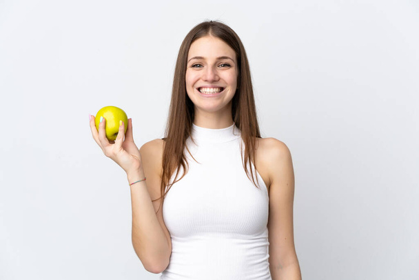 jonge Kaukasische vrouw geïsoleerd op witte achtergrond met een appel en gelukkig - Foto, afbeelding