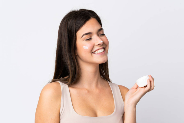 Ragazza brasiliana adolescente con crema idratante su sfondo bianco isolato - Foto, immagini