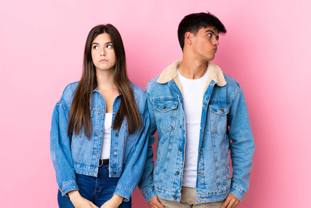 Young couple over isolated pink background nervous and scared - Foto, Imagem